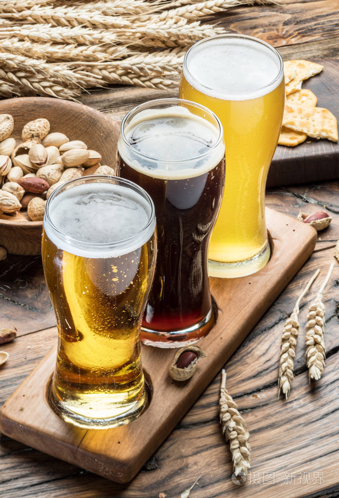 啤酒和小吃木制的桌子上的眼镜