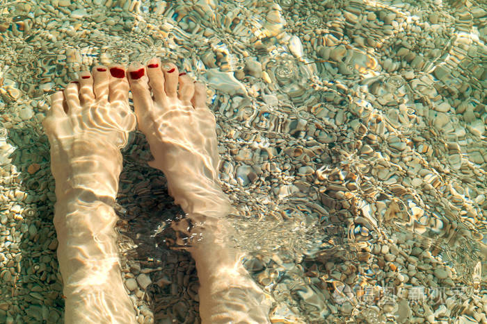 在水下的红色指甲油的女性脚