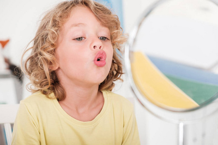 在正确的发音课堂上学习在镜子前说话的孩子照片