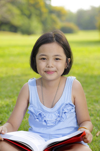 亚洲小女孩读本书在公园