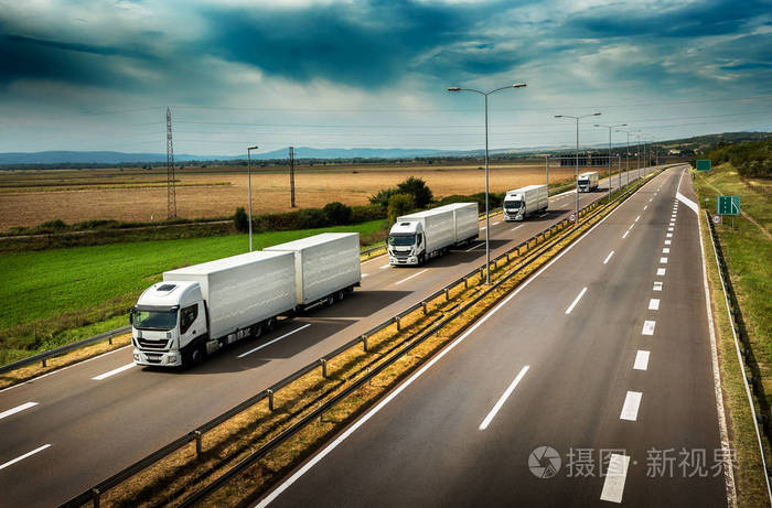 在乡间公路上排队的白色卡车卡车的大篷车或车队