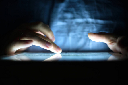 裁剪的人的图像使用数字平板电脑在黑暗中与霓虹灯