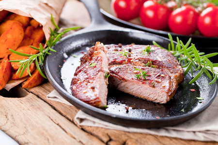 中度稀有烤牛肉, 土豆黑石背景。顶部视图, 平躺