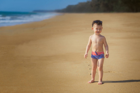站在沙滩上的小男孩的全长镜头