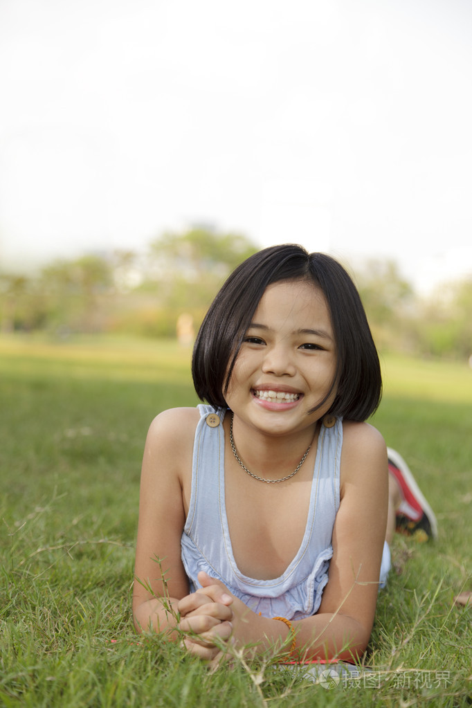 亞洲小女孩放鬆,在公園裡笑的很開心