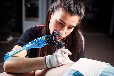 由专业艺术家纹身制作是纹身身体妇女使用机器在一个创意设计工作室