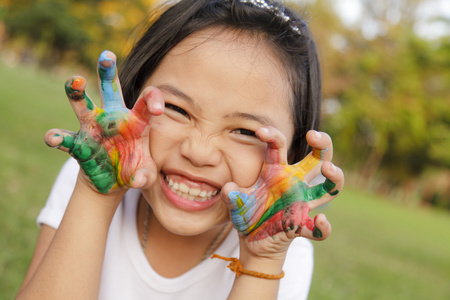 亚洲小女孩用手绘多彩涂料中