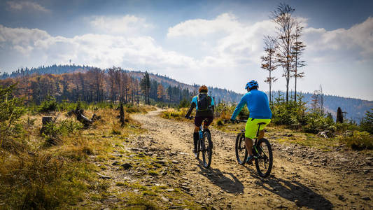 男人和女人骑自行车山地车流动上山的小道照片