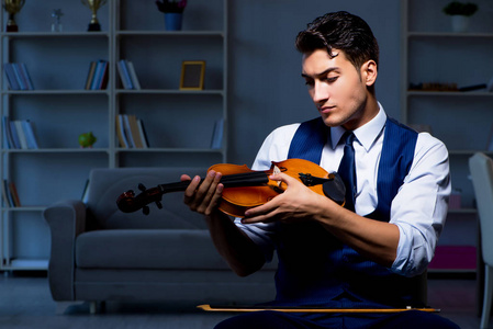 年轻的音乐家人练习小提琴在家里