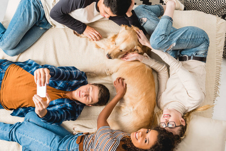 多文化青少年躺在床上, 带狗自拍的开销观