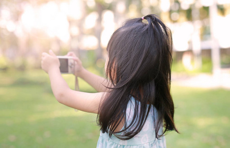 儿童女孩在花园里的相机拍照