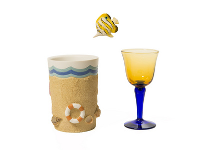 黄色小鱼跳入隔离在白色背景上的海滩杯