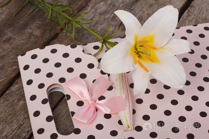 粉红色礼品纸袋和桌上的白百合花