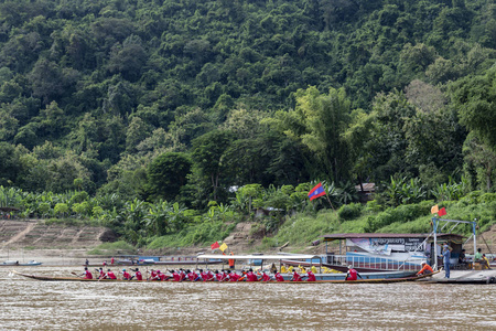 老挝琅勃拉邦10月4日 在 2017年10月4日, 老挝琅勃拉邦的佛教出借船比赛结束时, 身着红色衣服的不明身份人士等待。