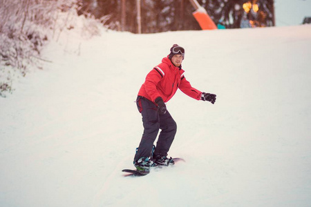 主动男子滑雪在红色夹克骑在斜坡上, 滑雪板