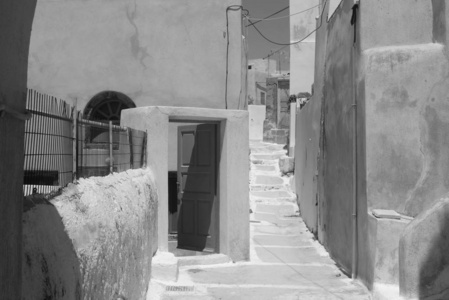 在安普里奥阿玛尼的一个狭窄的街道上的夏日天, 在圣托里尼岛上