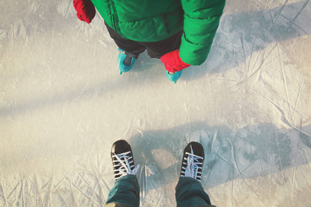 父亲和孩子学习滑冰在冬天