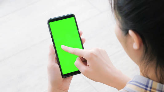 妇女在家使用手机与绿色屏幕