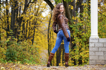 秋季时尚形象的年轻女子在公园散步