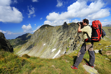 自然摄影师拍照在山图片
