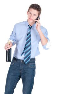 年轻商务男人身穿蓝色衬衫和领带与瓶酒在电话上说