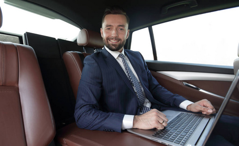 成功使用笔记本电脑坐在车里的男人