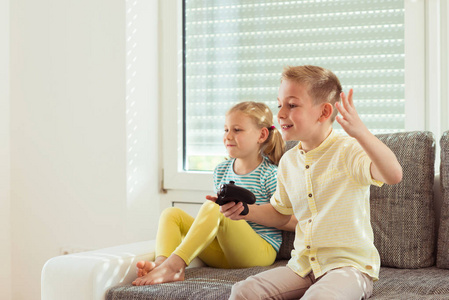 两个快乐的孩子们玩视频游戏在家里