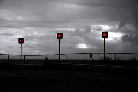 路的尽头。沿海街道的尽头。寂静的街道以栅栏和红色红绿灯结束。灰色, 阴郁的心情