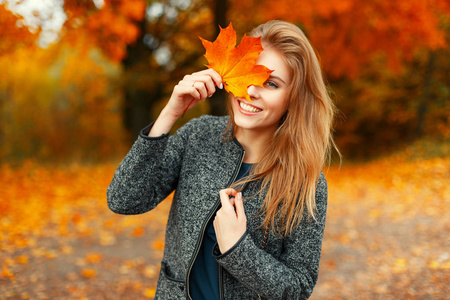 秋天公园里有鲜艳的黄叶的美丽幸福的女人