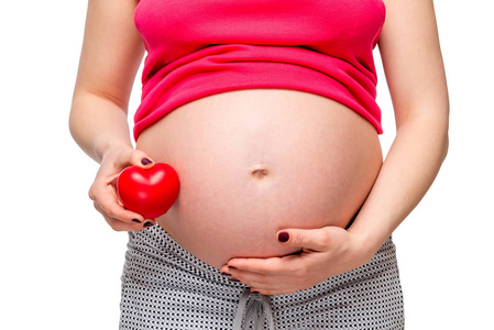 一个红色的心脏形状的孕妇腹部特写