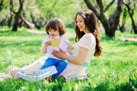 母亲节快乐家庭野餐。在春季或夏季公园里, 妈妈和孩子在户外吃甜食