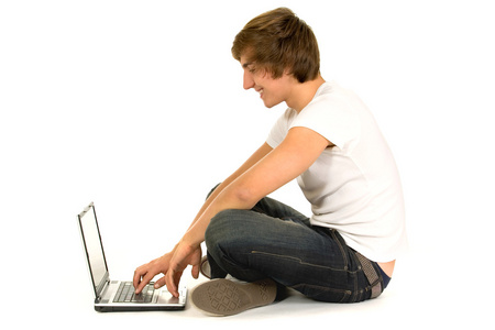年轻人坐在地板上有笔记本电脑上