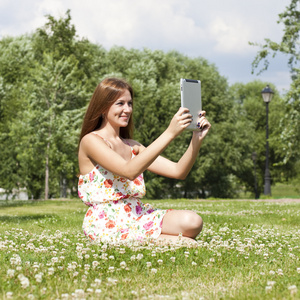 年轻女子坐在绿色的草坪上的肖像