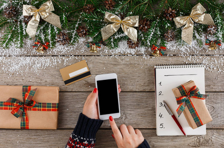 在线购物的圣诞礼物在智能手机上的女人