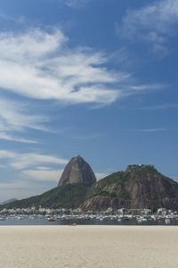风景与从博塔福格海滩的糖面包山在晴朗的天与美丽的云彩和蓝色天空, 里约热内卢, 巴西
