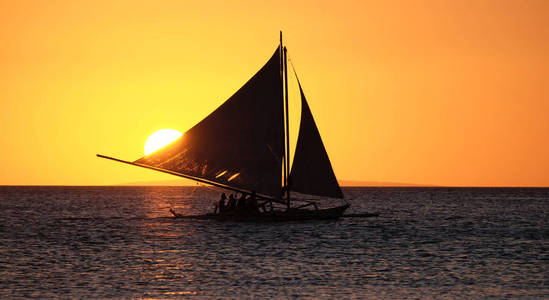 长滩岛腓日落海面上的帆船图片