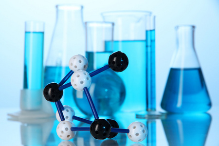 分子模型和试管在蓝色背景上的液体