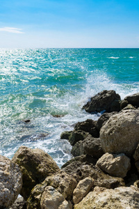 蓝色海浪在明亮的黄色石头上海浪。蔚蓝的大海和喷雾在阳光明媚的一天在岸上, 放松