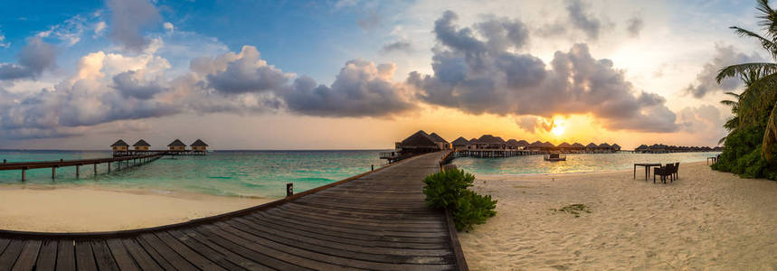 夏季傍晚在马尔代夫热带海滩上热带日落上空的全景