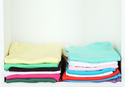 整齐地折叠在货架上的衣服照片