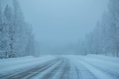 晚上北部森林。空公路。大量的雪和雾