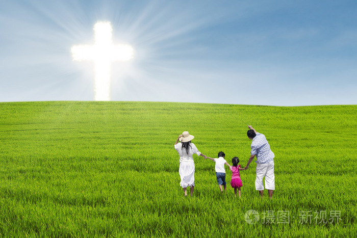 在绿色的原野上的基督徒家庭