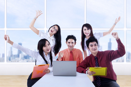 业务团队为室内的成功欢呼照片