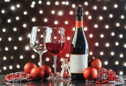 圣诞节和新年。节日装饰品, 红酒瓶和两杯背景灯