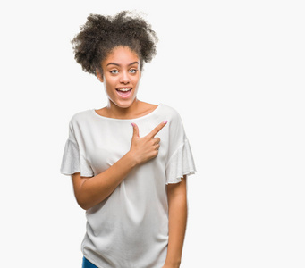 年轻的美国黑人妇女在孤立的背景开朗与微笑的脸指着手和手指到一边与快乐和自然的表情看着相机