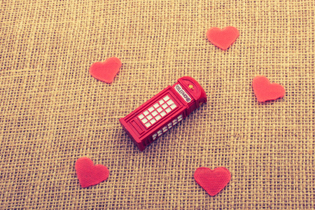 红色的心围绕红色的电话亭在画布上