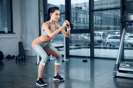 年轻运动的妇女做蹲在健身房