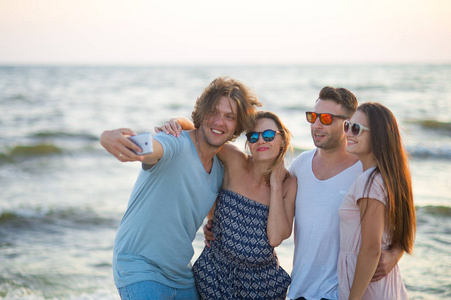 一群快乐的年轻人在海滩上拍照