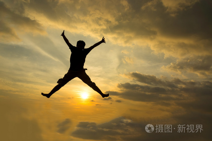 男子跳跃在日落时分的剪影