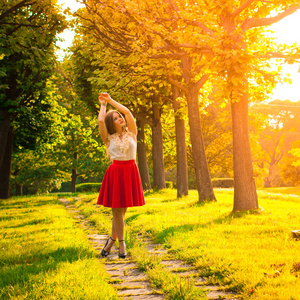 在公园的一条红裙子的年轻女孩的肖像